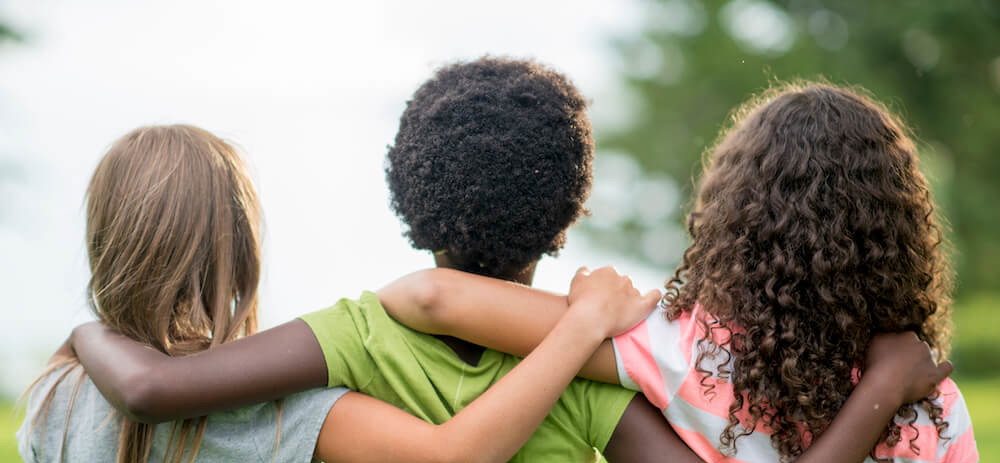 Children with their arms around each others shoulders