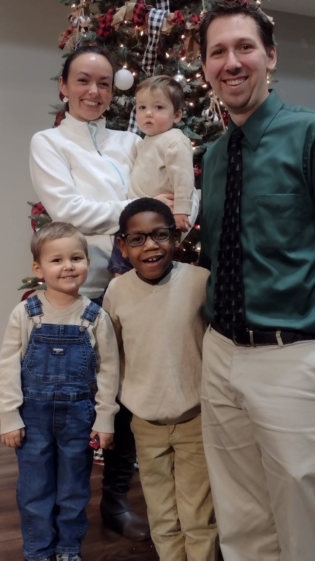 Family Christmas photo in front of the Christmas tree