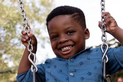 Boy smiling on playground swing